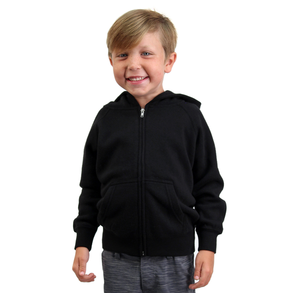 Boy poses in front of a white background and is wearing a black zip-up hoodie.