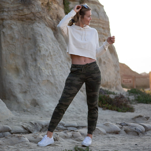 Woman poses in green camouflage sweatpants.