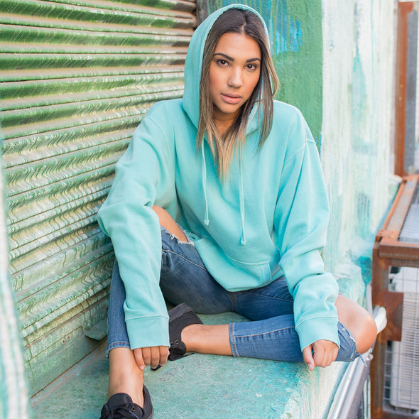 Woman poses in a pastel mint pullover hoodie.