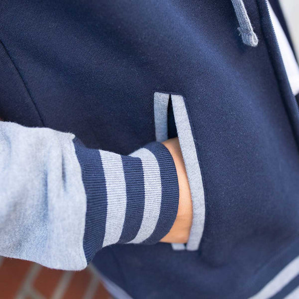 Close up of university hoodie with striped cuffs and front pocket.