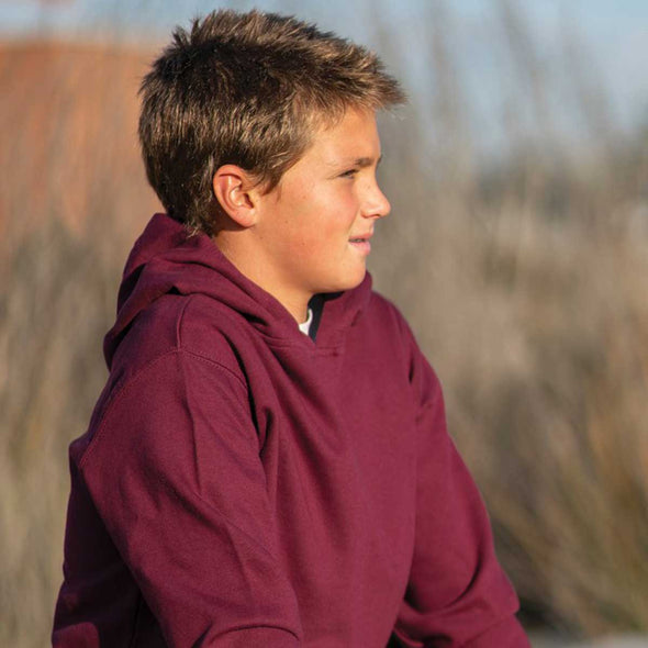 Close up of boy wearing a maroon pullover hoodie.