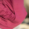 Close up of kangaroo pocket on a maroon pullover hoodie.